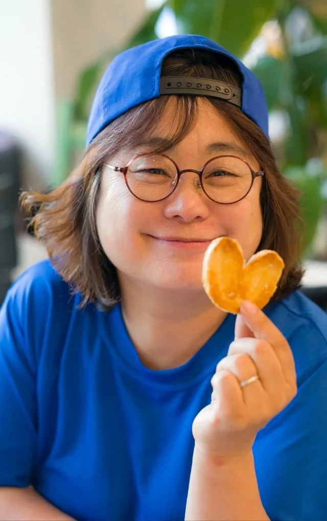 차지영 — 파란 모자를 쓰고 하트 모양 과자를 든 모습